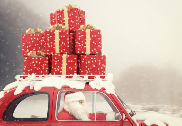 بابا نوئل یک ماشین قرمز پر از کریسمس هدایت می کند