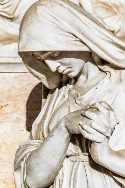 مجسمه از زن غمگین به دنبال پایین با چسبیده سر و دست در نماز