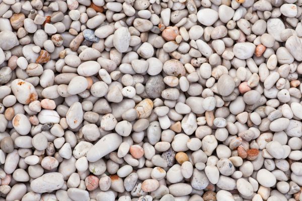 سنگ طبیعی در ساحل دریا به طور طبیعی گرد شده است الگوی بافت طبیعت پس زمینه