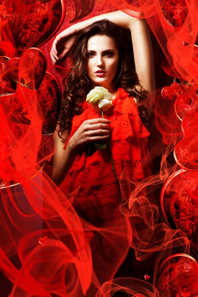 زن زیبای عاشق در لباس قرمز اطراف پارچه