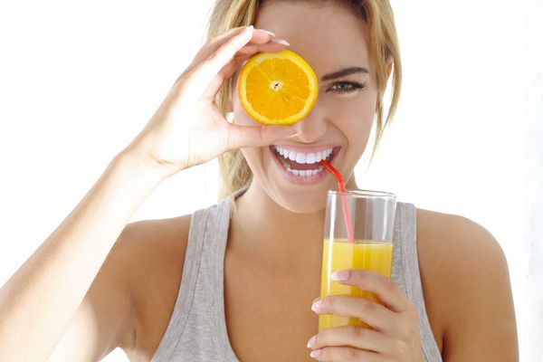 زن جوان با آب پرتقال