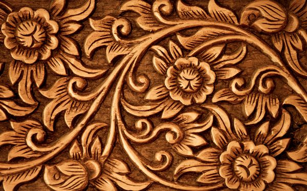 الگوی گل حک شده در پس زمینه چوب