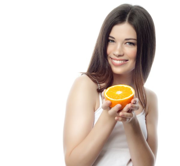 پرتره زن زیبا لبخند زن قهوه ای جدا شده در استودیو سفید با پرتقال
