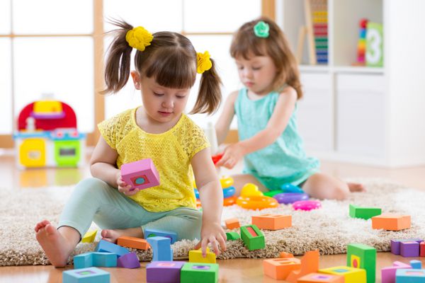 کودکان و نوجوانان با اسباب بازی رنگی رنگی دو بچه برج های ساختمان در خانه و یا مرکز مهد کودک اسباب بازی های آموزشی کودکان برای مهد کودک و مهد کودک