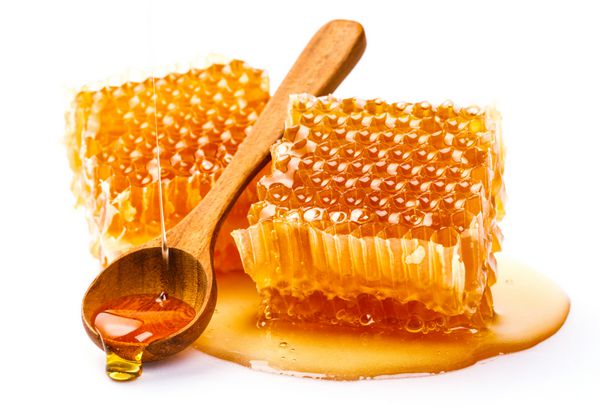 لانه زنبوری با قاشق عسل جدا شده بر روی زمینه سفید