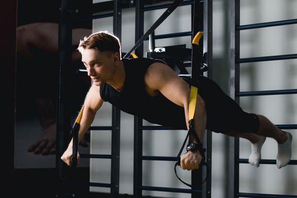 آموزش TRX مربی متقابل مناسب در ورزشگاه TRX Excersise تمرین تناسب اندام در حلقه ها مرد تناسب اندام در ورزشگاه سبک تناسب اندام تمرین روی حلقه ها ورزش و تناسب اندام تمرین تناسب اندام