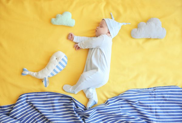 بچه کوچک ناز با اسباب بازی خواب در رختخواب در خانه