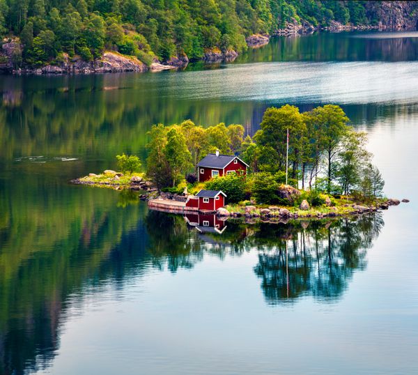نمایش منظره تابستانی با جزیره کوچک با ساختمان نروژی معمولی در Lovrafjorden فورج دریای شمال نمایش صبح رنگارنگ در نروژ زیبایی از پس زمینه مفهوم طبیعت
