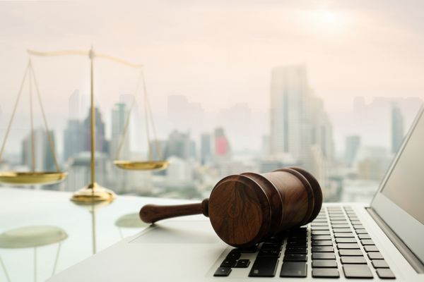 قانون مفهوم حقوقی حقوقی قاضی دادگاه را بر روی کامپیوتر با مقیاس عدالت بر روی میز وکیل قرار دهید