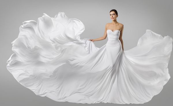 لباس زنانه سفید مدل مد در لباس بلند سیلک تکان دادن پارچه پرواز لگد زدن به باد