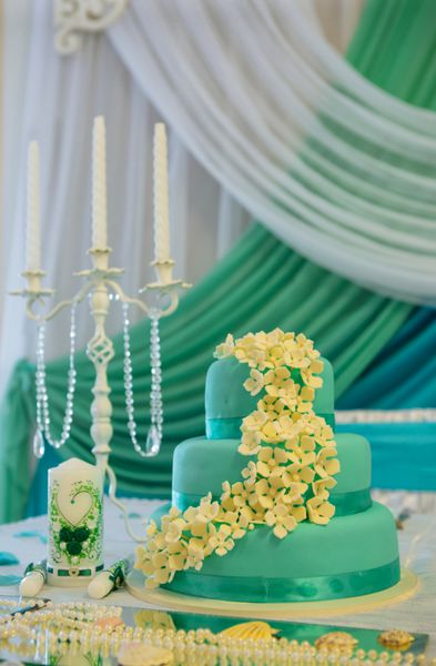 کیک عروسی در رنگ های سفید فیروزه ای میز عروسی با شمع