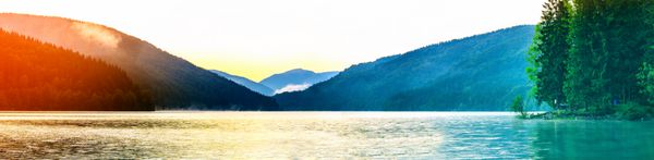 چشم انداز پانوراما در یک دریاچه بزرگ در صبح کوه ها درختان و اردوگاه گردشگری