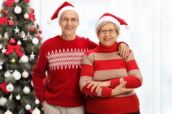 زن و شوهر ارشد شاد با کلاه سانتا در مقابل کریسمس t