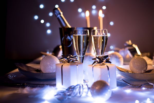 نور کم نور نور سفید و آبی عاشقانه سال نو یا میز کریسمس در یک رستوران لوکس با شامپاین