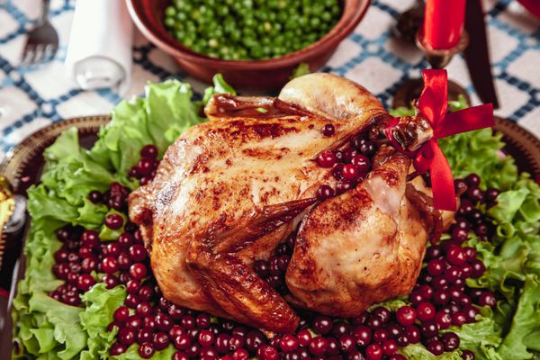مرغ سرخ شده تنظیم میز میز شکرگذاری با بوقلمون پخته شده تزئین شده با کاهو و دانه های انار است شام کریسمس توسط نور شمع