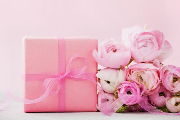 گل های زیبا Ranunculus گل و جعبه هدیه در پس زمینه خاکستری رنگ پاستل کارت تبریک برای روز ولنتاین یا روز زنان فضای خالی برای متن