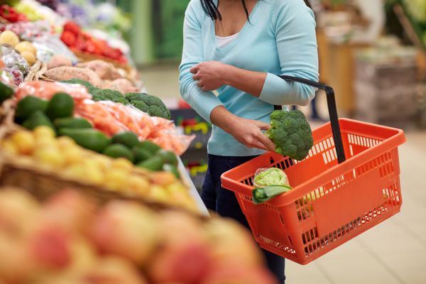 زن با سبد خرید بروکلی در فروشگاه مواد غذایی