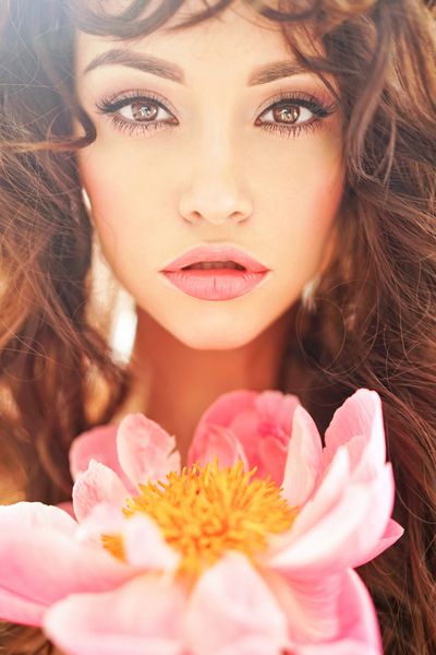 زن جوان زیبا با گل صد تومانی بزرگ