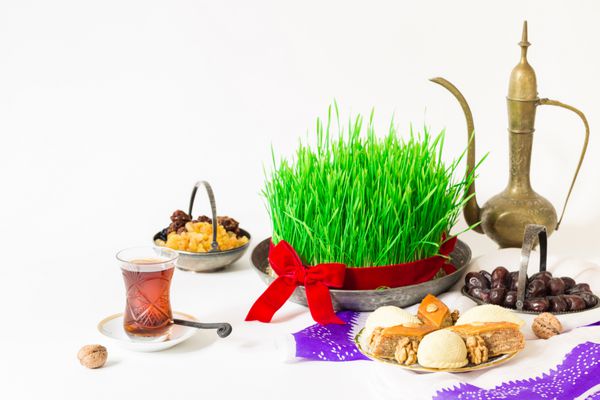 Novruz ملی آذربایجان تعطیلات بهار سال نو جشن مفهوم گندم چمن semeni گلابی شکل لیوان چای و pakhlava سنتی shekerbura و میوه های خشک و kelagai پرنعمت شیشه سفید پس زمینه