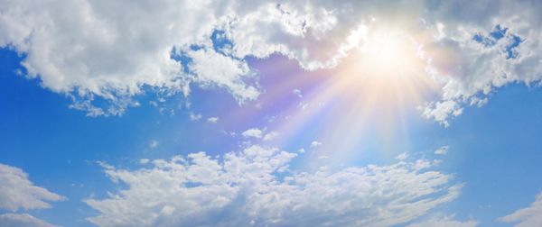 پانورامای پانوراما آسمان آسمانی شگفت انگیز آسمان آبی رنگ ابرهای کرکی و یک گرم خورشید پر زرق و برق رنگی گرم و پر نور و تصویر برداری از یک موجود مقدس