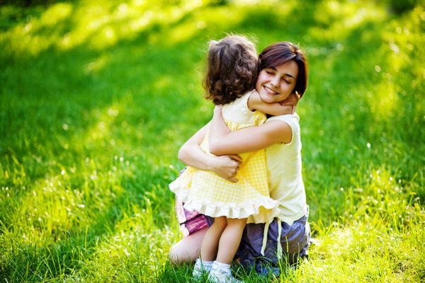 مادر جوان زیبا و دخترش لذت بردن از چمن سبز