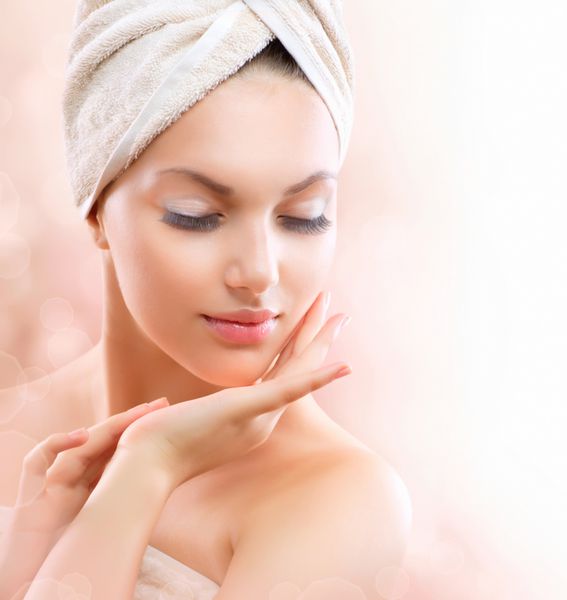 دختر اسپا زن زیبا جوان پس از حمام به لمس صورت او پوست کامل محصولات مراقبت از پوست پوست جوان