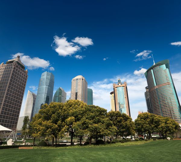 سبز شهری شهر با ساختمان مدرن علیه آسمان آبی در شانگهای