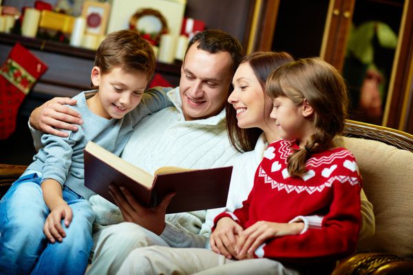 پرتره کتاب خواندن خانواده دوستانه در شب کریسمس