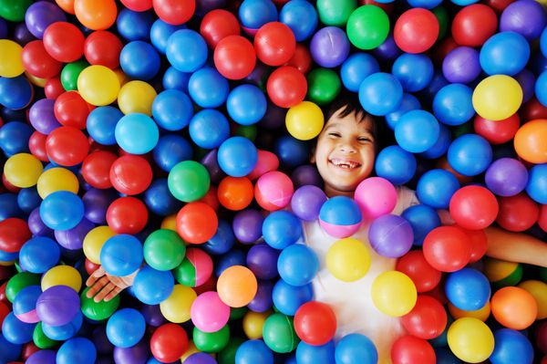 کودکان شاد و لذت بخش در مهد کودک با توپ های رنگی