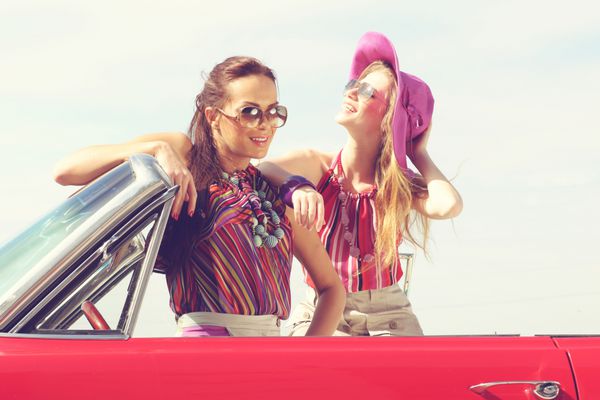 خانم های زیبا با عینک آفتابی در یک ماشین پرنعمت قرار می گیرند