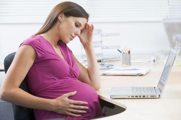 زن باردار در کار با لپ تاپ به دنبال تأکید است