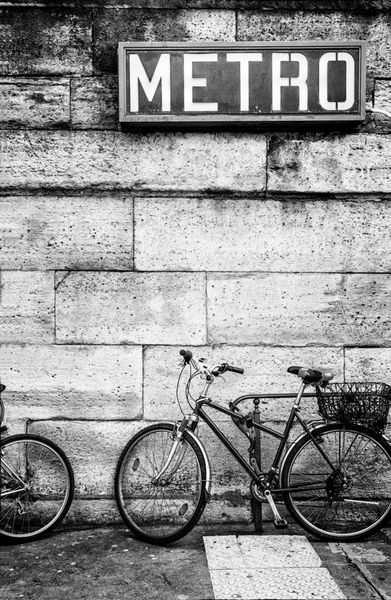 دوچرخه سوار بر یک دیوار سنگی تحت پارک مترو فرانسوی پارک شده است تصویر سیاه و سفید فضای کپی کنید
