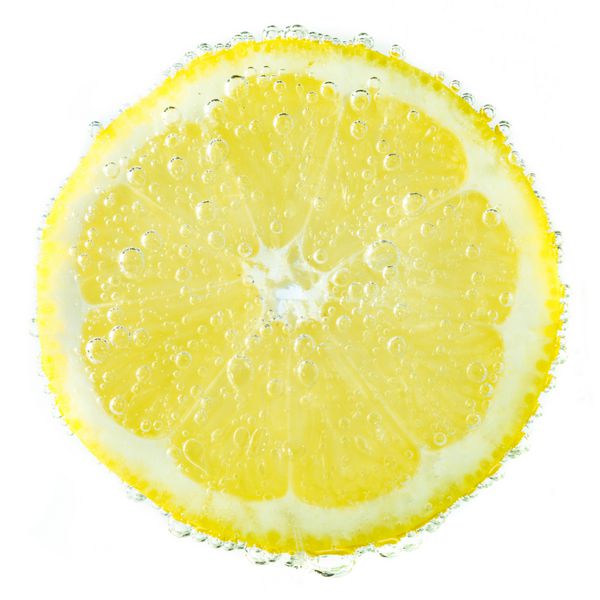 لیمو تازه در آب گوجه فرنگی با حباب در پس زمینه سفید پوشانده شده است