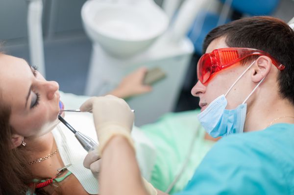 دندانپزشک یک بیمار زن را درمان می کند دندانپزشک در کابینه او