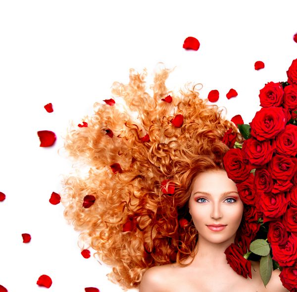 مدل زن زیبایی با موی قرمز موی قرمز و قرمز گلهای رز قرمز با گل و گلبرگ دختر مد با موهای سالم موی جدا شده بر روی زمینه سفید