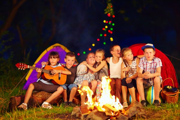 بچه های خوش تیپ آواز خواندن در اطراف آتش اردوگاه
