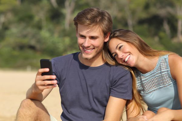 زن و شوهر نوجوان مبارک به اشتراک گذاری رسانه های اجتماعی در تلفن های هوشمند خارج از منزل