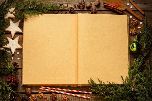 پس زمینه کریسمس کتاب باز کتاب خالی قدیمی با دکوراسیون در اطراف میز مقدماتی چوب بلوط از بالا چیدمان با فضای متن آزاد