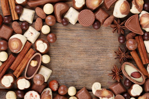 قاب از انواع شکلات بر روی میز چوبی نزدیک