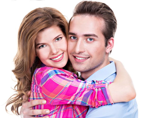 زن و شوهر زیبا شاد در آغوش نگاه به دوربین در پس زمینه سفید