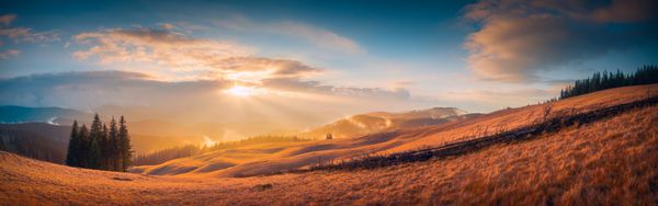 پانوراما غروب خورشید در یک دره کوهستانی کارپات با نور طلای شگفت انگیز بر روی تپه ها