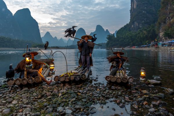 XINGPING CHINA 2014 اکتبر 21 ماهیگیر کوهستان در قایق بادبانی باستانی با چراغ های روشن و باله Li River Xingping China