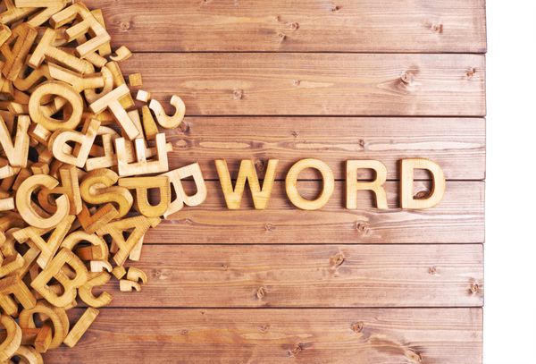 کلمه کلمه ساخته شده با چوب بلوک چوبی در کنار یک شمع از نامه های دیگر بیش از ترکیب سطح تخته چوبی