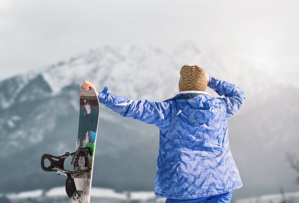 دختر فعال با اسنوبرد در دید کوه برفی