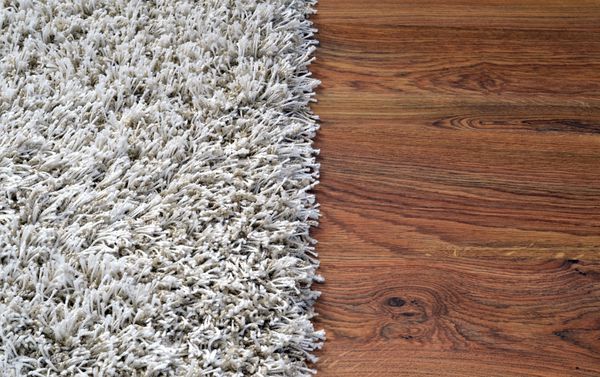 دو بخش تصویر تقسیم شده از فرش سفید و پشمالو و کف چوبی قهوه ای