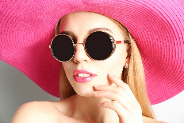 پرتره مدل جوان بیانگر در کلاه صورتی و عینک آفتابی نزدیک