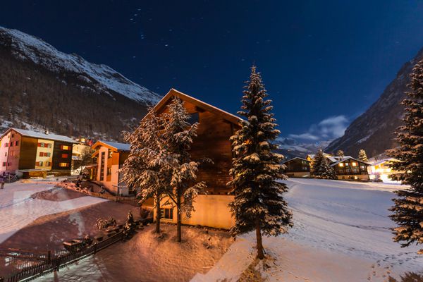 دید در شب زمستان با آسمان روشن دره لشگر دروازه به Zermatt سوئیس