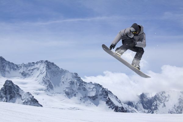 پرواز snowboarder در کوه ورزش زمستانه شدید