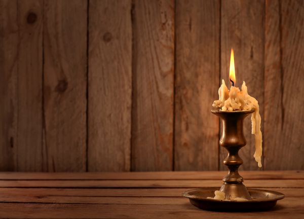 سوزاندن شمعدان برنزی قدیمی شمع قدیمی بر روی زمینه های چوبی