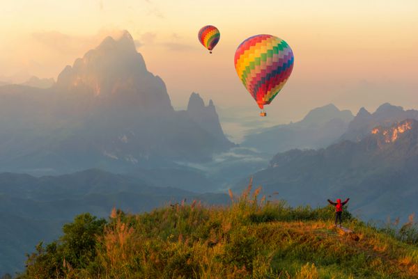 بالن های گرم و گرم رنگارنگ پرواز بیش از کوه و مسافر مفهوم سفر